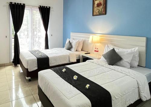 a hotel room with two beds and a window at TOS Hotel & Convention Center Tangerang Powered by Archipelago in Tangerang