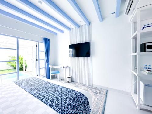 a white room with a bed and a tv at Jungwok Blue Ocean Resort in Ngandong