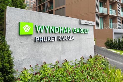ein Schild für den Windsham Garden Plunkett Kawasaki in der Unterkunft Wyndham Garden Phuket Kamala in Kamala Beach