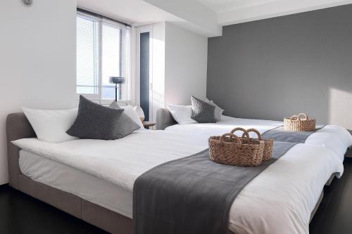 two beds with baskets on them in a bedroom at サンコート月寒中央通 in Sapporo