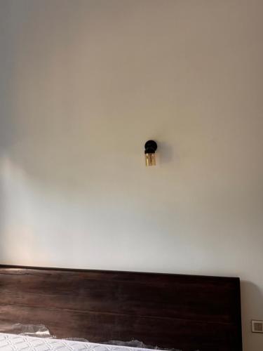 Un dormitorio con una pared blanca con cabecero de madera. en Leafy Haven Villa, en Liyanegoda