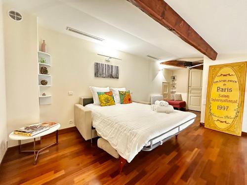 ein Schlafzimmer mit einem großen Bett und einem Tisch in der Unterkunft Rose 2 duplex-clim-plage in Menton