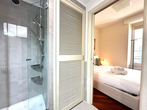 ein Badezimmer mit Dusche und ein Bett in einem Zimmer in der Unterkunft Rose 2 duplex-clim-plage in Menton