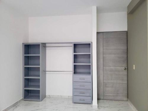een kamer met drie kasten met lege planken bij Departamento Céntrico in Monterrey
