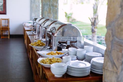 een buffetlijn met borden en kommen met eten bij Charm Hon Rom Villas Resort in Ấp Long Sơn