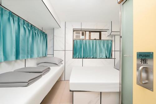 Un baño con dos camas y una ventana. en Joy Hella Inn, en Hong Kong