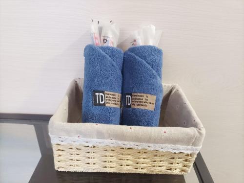 Una cesta con cepillos de dientes y toallas sobre una mesa. en Joy Hella Inn, en Hong Kong
