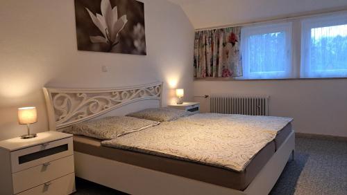 a bedroom with a bed and two lamps and a window at Ferienwohnung Auguste in Munster