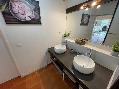 a bathroom with two sinks and a mirror at Ti coin de paradis Anse des Rochers in Saint-François