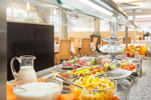 a buffet line with many dishes of food and milk at Kurhotel Pyramide Sibyllenbad in Neualbenreuth