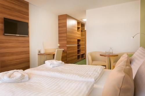 a hotel room with two beds and a television at Kurhotel Pyramide Sibyllenbad in Neualbenreuth