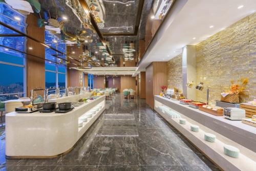 un restaurant avec une longue ligne de comptoirs dans l'établissement Dalian Zhongshan Square Seaview Meilun Hotel, à Dalian