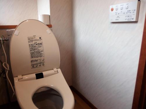 a bathroom with a toilet with the lid up at Berg Marukaneya in Nozawa Onsen