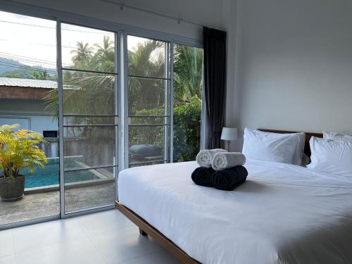 ein Schlafzimmer mit einem großen Bett, auf dem Handtücher liegen in der Unterkunft 2 Bed 2 Bath Private Pool Villa Near Beach in Nathon Bay