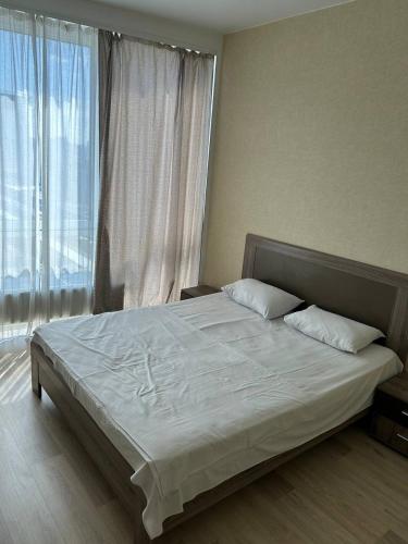 a large bed in a room with a large window at Apartmant in Smart Plaza in Kyiv