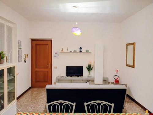 een kamer met 2 stoelen en een bureau met een televisie bij La casa di Sergiò in Belgioioso