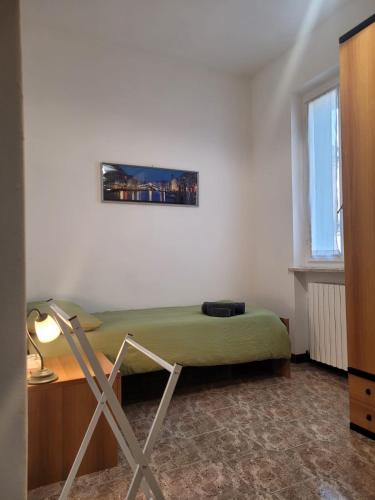 a bedroom with a green bed and a desk and a window at La casa di Sergiò in Belgioioso