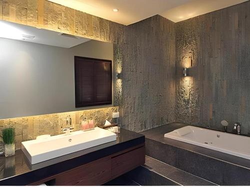 a bathroom with a sink and a bath tub at Azaya Villas Resort in Ban Mai Na Hi