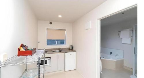 cocina blanca con encimera y fregadero en Hawera Central Motor Lodge, en Hawera