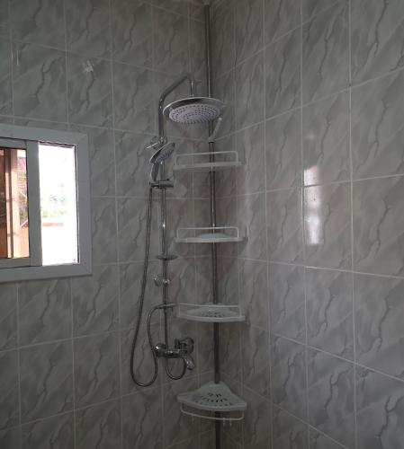 een douche met vier planken in een badkamer bij JEK Villa in Brufut