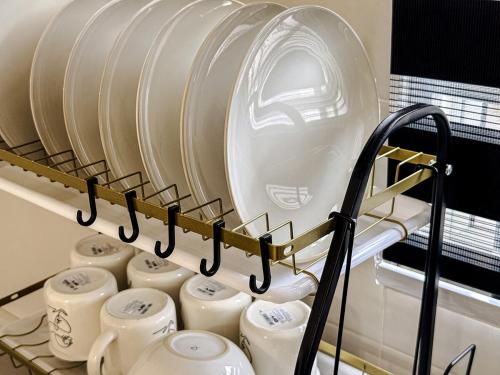 Un estante con un montón de tarros de leche blancos en Family-Friendly Landed 2BR 8 Pax Netflix and WiFi, en Kamunting