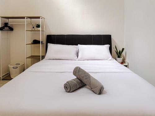 Un animal de peluche está acostado en una cama en Family-Friendly Landed 2BR 8 Pax Netflix and WiFi, en Kamunting