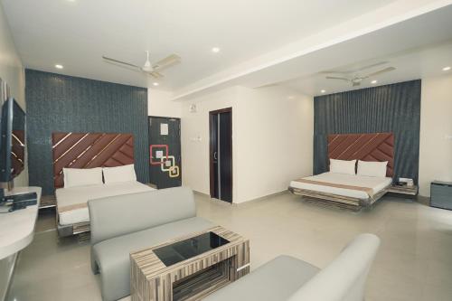 a hotel room with two beds and a couch at Hotel JP - 100 meters from the beach in Digha