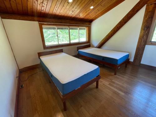 MeraA private log house in a secluded beach, LOGOUT的房间里有两张床，天花板是木制的