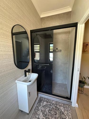 a bathroom with a sink and a mirror at Little Nest in Somerset West