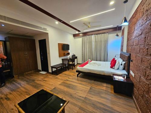 a hotel room with a bed and a desk at Nirmallyam Residency Hotel in Edappāl