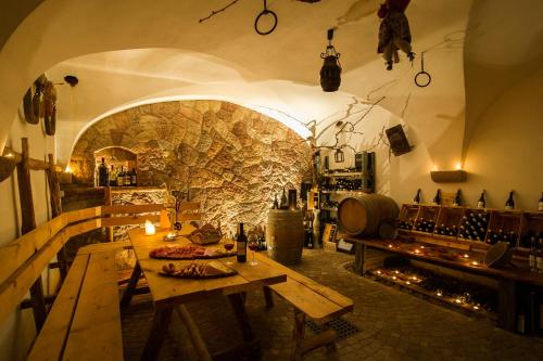 a room with wooden tables and a stone wall at Gutshof Sinn in Caldaro