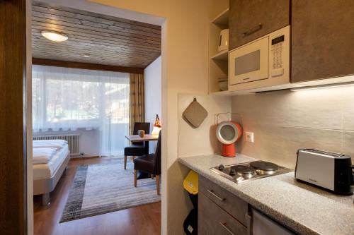 een keuken met een wastafel en een bed in een kamer bij Haus St. Michael in Oberndorf in Tirol