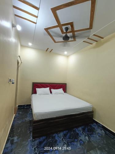 a bedroom with a bed and a ceiling fan at Hotel Maa Dham Palace in Ayodhya