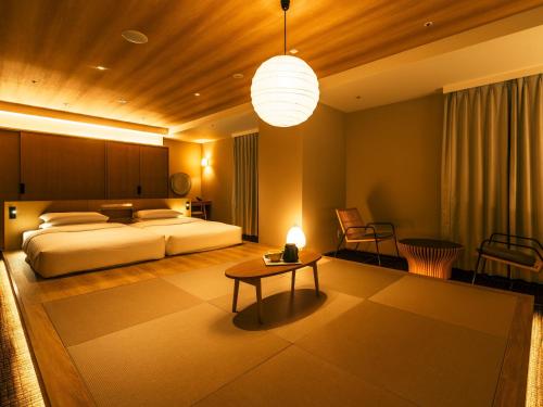 a bedroom with a bed and a table and a lamp at Richmond Hotel Premier Tokyo Schole in Tokyo
