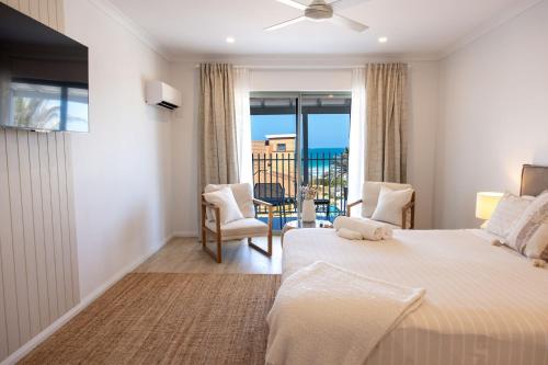 ジェラルトンにあるThe African Reefの大きなベッドとバルコニーのある寝室