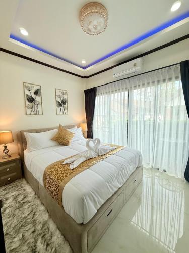 a bedroom with a large bed and a window at PS House Bangtao in Bang Tao Beach