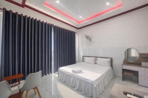 um quarto com uma cama branca e um espelho em Ngọc Nga Hotel em Phan Rang