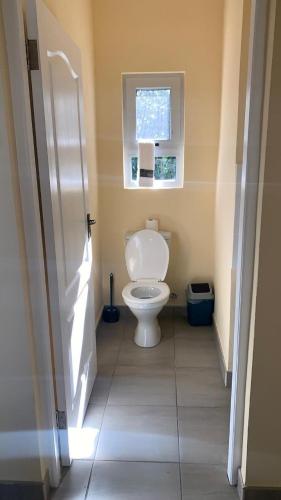 a bathroom with a toilet and a window at Vista Alta Serma in Ponta Malangane