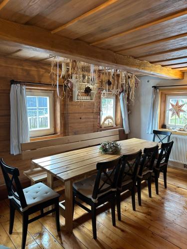 a dining room with a wooden table and chairs at Chata "Na pohodu" in Chřibská
