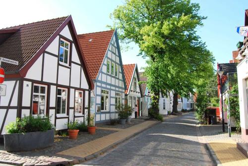 een geplaveide straat in een stad met witte en blauwe huizen bij Ferienwohnung Warnemünde Altstadt (RC) in Warnemünde