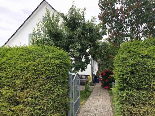 ein Zaun vor einem Haus mit Büschen in der Unterkunft Ferienwohnung mit Garten in Wieck