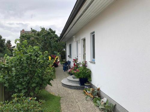 einen Fußweg neben einem Haus mit Blumen und Pflanzen in der Unterkunft Ferienwohnung mit Garten in Wieck