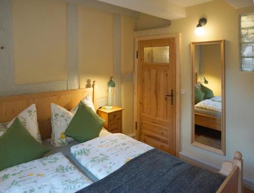 a bedroom with a bed and a mirror at Klopstock´s Herberge in Quedlinburg
