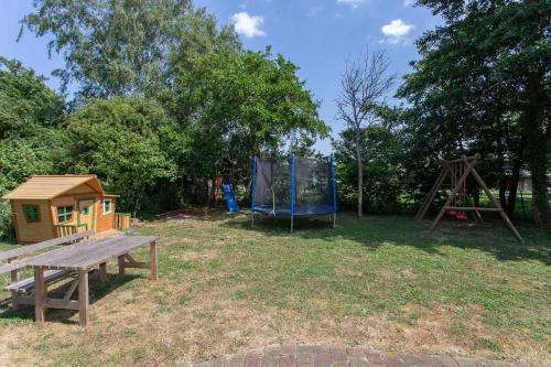 a park with a wooden picnic table and a playground at Villa Boddenblick in Wiek auf Rügen