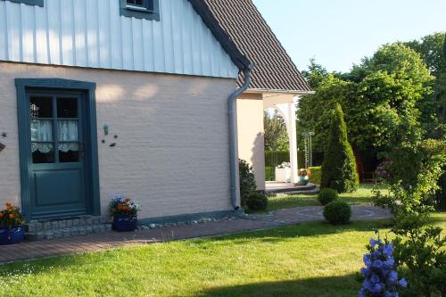 a house with a green door and a yard at Ferienwohnungen im Klönhus in Prerow