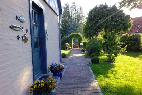 a brick walkway next to a house with flowers at Ferienwohnungen im Klönhus in Prerow