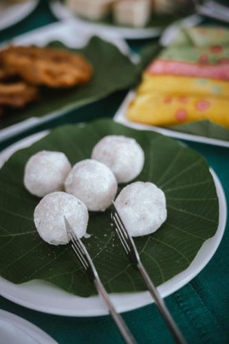 Un plato de bolas de arroz sobre una hoja verde. en Ayurveda Spring Of Life Resort, en Piliyandala