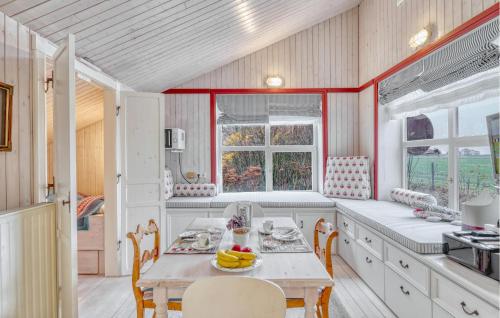 eine Küche mit einem Tisch, Stühlen und Fenstern in der Unterkunft Gorgeous Home In Galmsbüll in Galmsbüll