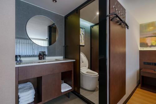 a bathroom with a toilet and a sink and a mirror at NOX Hotel in Chengdu