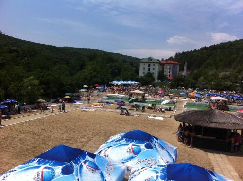a group of people on a beach with umbrellas at Hotel Monteoru in Sărata-Monteoru